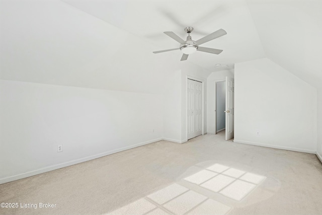 bonus room featuring lofted ceiling, ceiling fan, baseboards, and light colored carpet