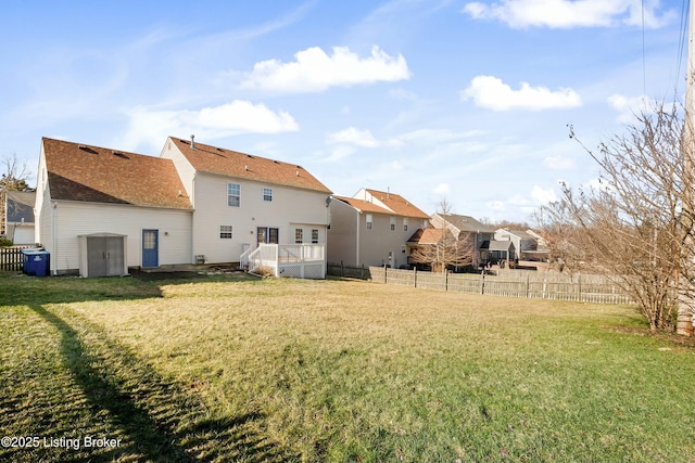 rear view of property featuring a lawn, a fenced backyard, and a residential view