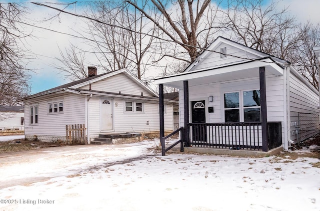 view of front of home featuring covered porch and a chimney