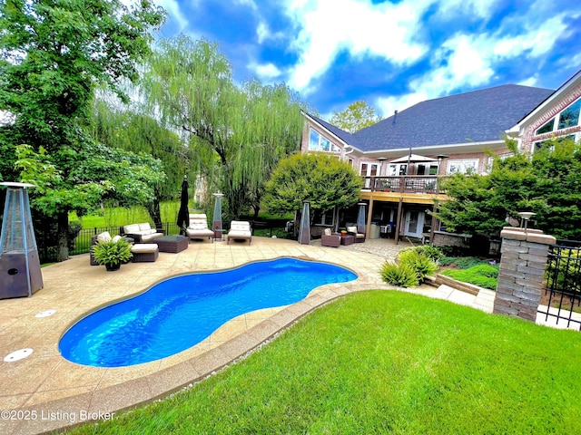 view of swimming pool featuring a patio, a yard, fence, and an outdoor hangout area