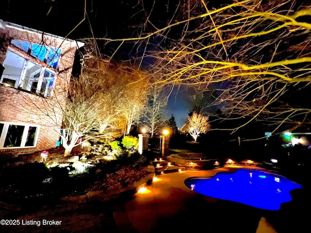 view of pool at twilight