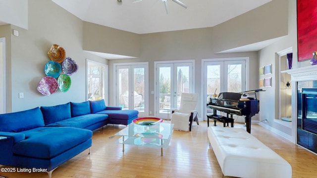 living room featuring french doors, baseboards, hardwood / wood-style floors, and a fireplace