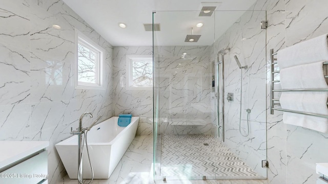 bathroom with a freestanding tub, visible vents, a marble finish shower, stone wall, and vanity