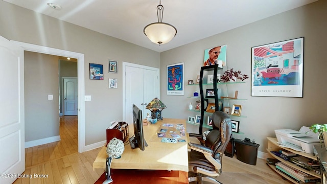 home office with baseboards and light wood finished floors