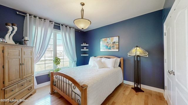 bedroom featuring light wood-style flooring and baseboards