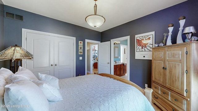 bedroom with ensuite bath, visible vents, and a closet