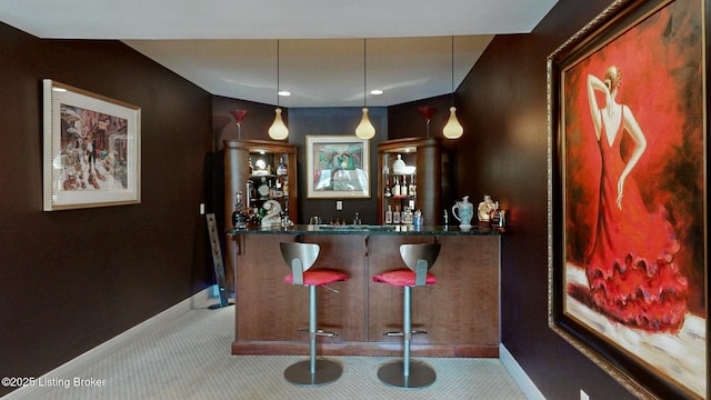 bar featuring baseboards, carpet, and a dry bar