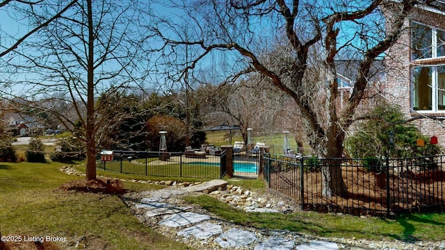 view of property's community featuring a pool, a yard, and fence