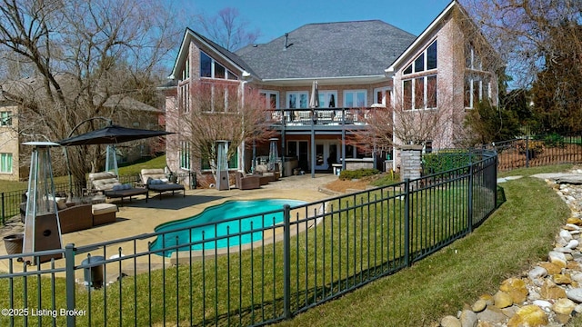 rear view of house with a patio, a yard, a fenced backyard, outdoor lounge area, and brick siding