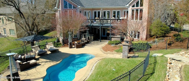 back of house featuring a patio, a yard, a fenced in pool, brick siding, and fence private yard