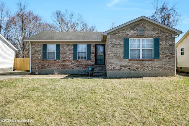 single story home featuring brick siding, a shingled roof, a front lawn, and fence