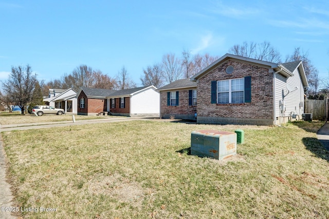 single story home with brick siding, central AC unit, a front lawn, and fence