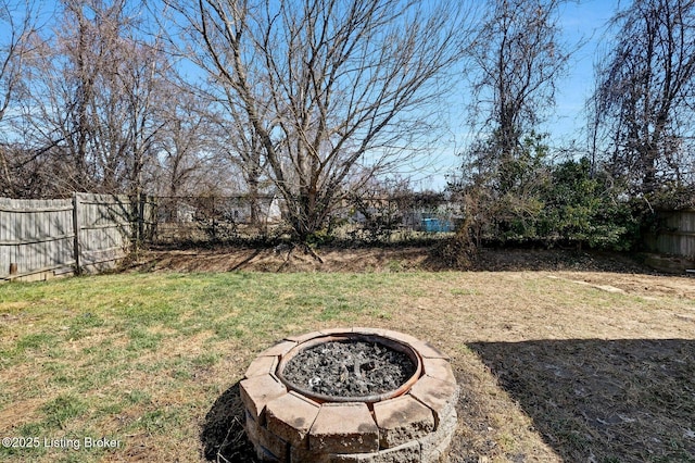 view of yard with an outdoor fire pit and fence