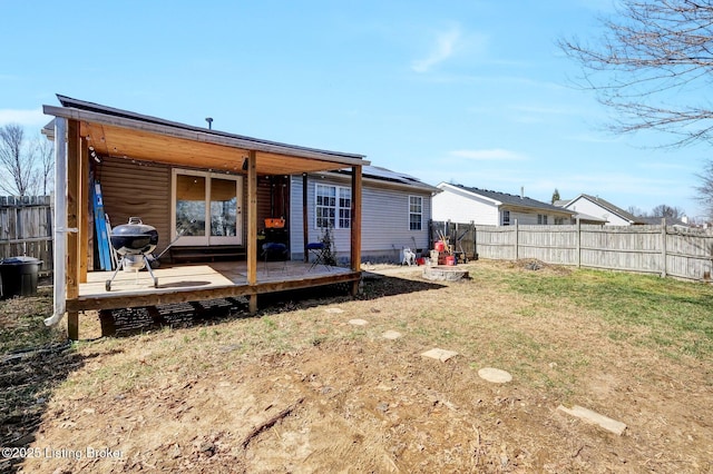 rear view of property with a lawn and a fenced backyard