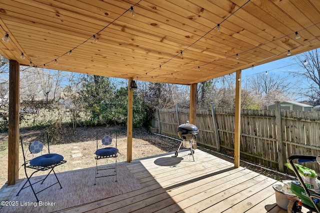 wooden terrace with fence and a grill