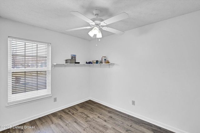 spare room with ceiling fan, a textured ceiling, baseboards, and wood finished floors