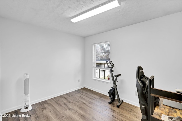 office area with wood finished floors, baseboards, and a textured ceiling