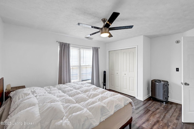 bedroom featuring baseboards, a closet, a textured ceiling, a ceiling fan, and dark wood-style flooring