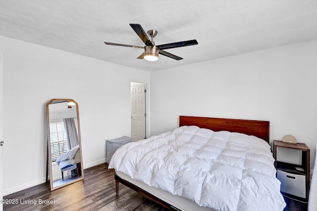 bedroom featuring baseboards, wood finished floors, and a ceiling fan