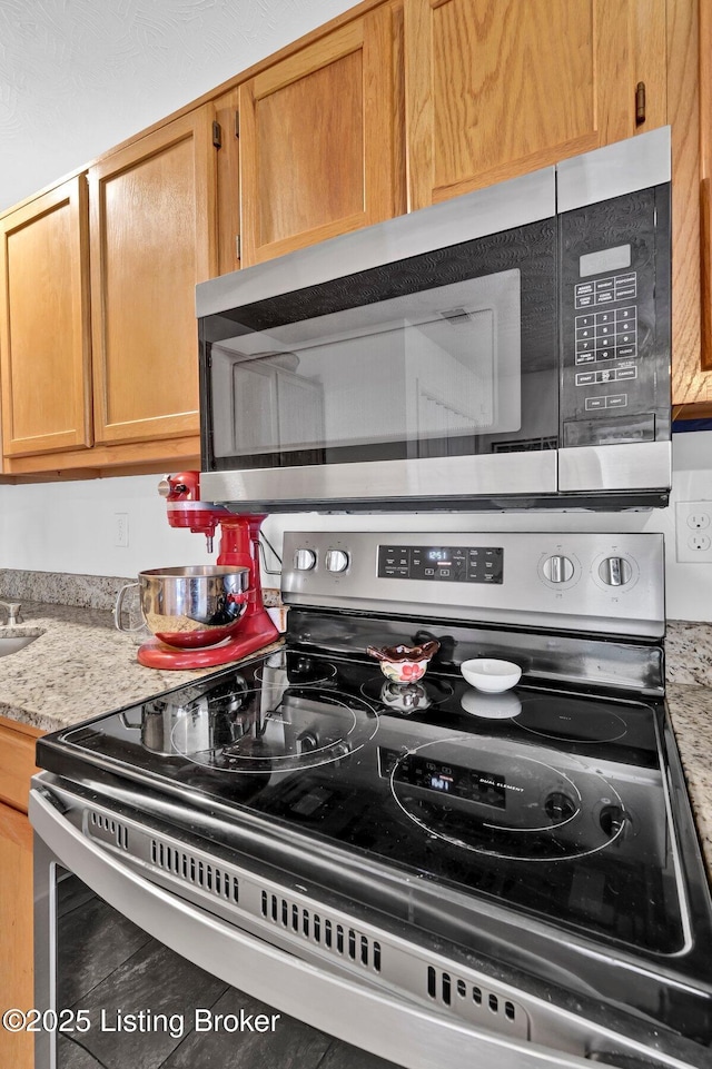 kitchen with appliances with stainless steel finishes and light stone countertops