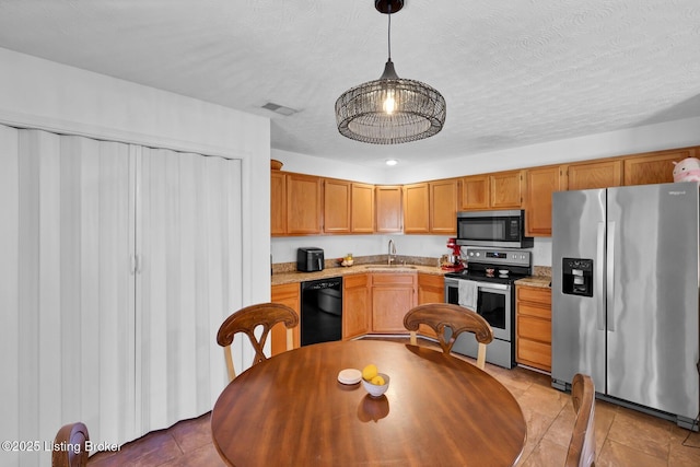 kitchen featuring visible vents, pendant lighting, a sink, a textured ceiling, and appliances with stainless steel finishes