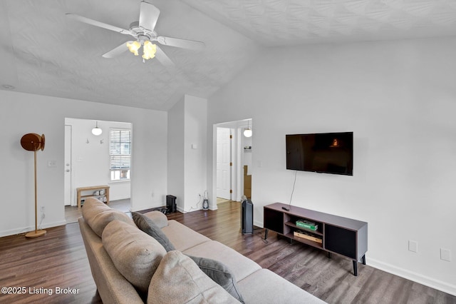 living room with baseboards, lofted ceiling, wood finished floors, and a ceiling fan