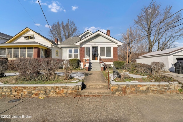 bungalow-style house featuring brick siding and a chimney