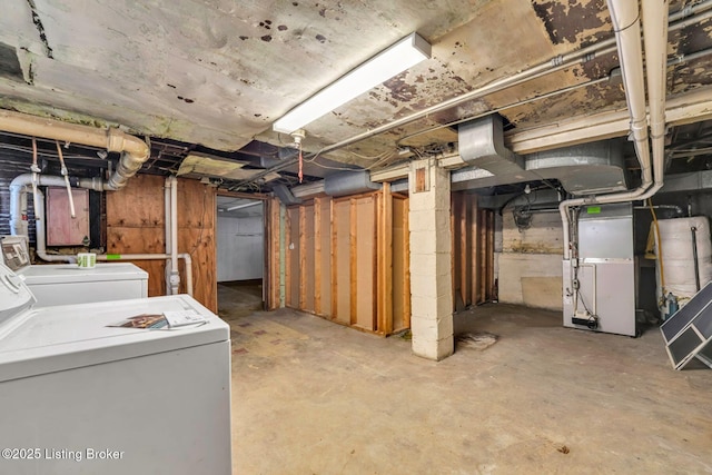 unfinished basement with heating unit and separate washer and dryer