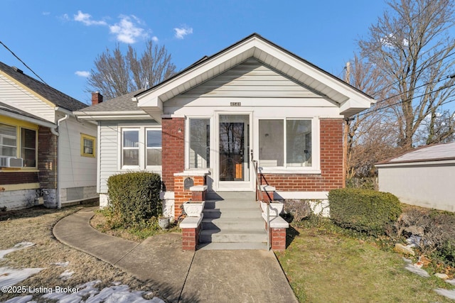 bungalow-style home with brick siding