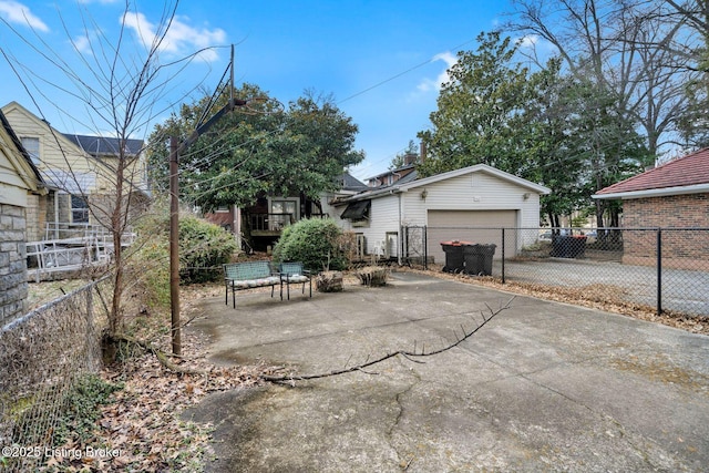 exterior space featuring a garage, an outbuilding, fence, and driveway