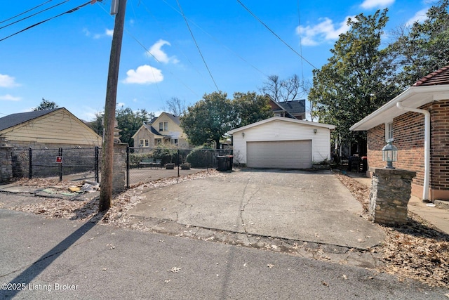 exterior space with an outbuilding, brick siding, a detached garage, and fence