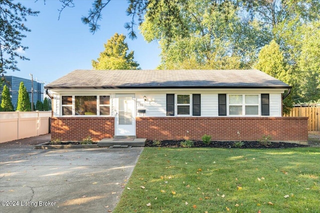 view of front facade with fence, a front lawn, and brick siding