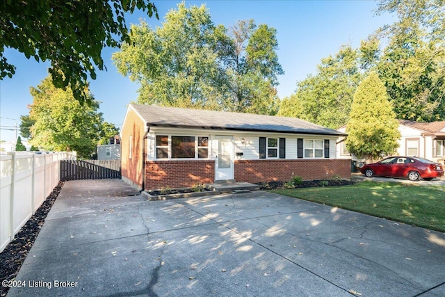 view of front of house with brick siding, fence, and a front lawn