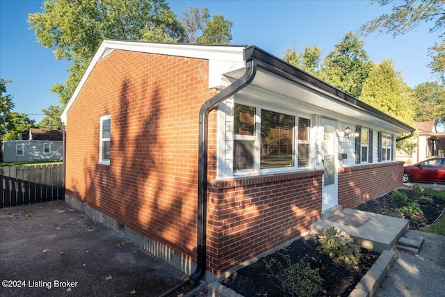 view of home's exterior with brick siding and fence