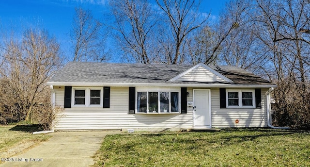 view of front of house with roof with shingles and a front yard