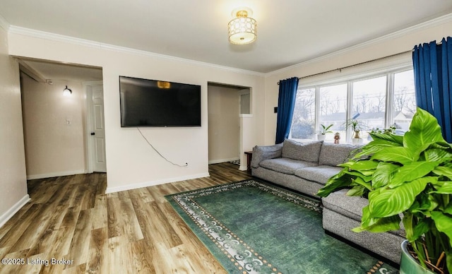 unfurnished living room with baseboards, ornamental molding, and wood finished floors