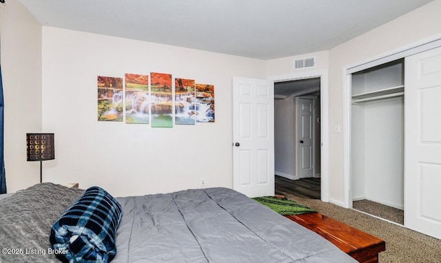 carpeted bedroom with baseboards, visible vents, and a closet