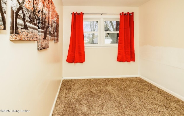 carpeted spare room featuring baseboards