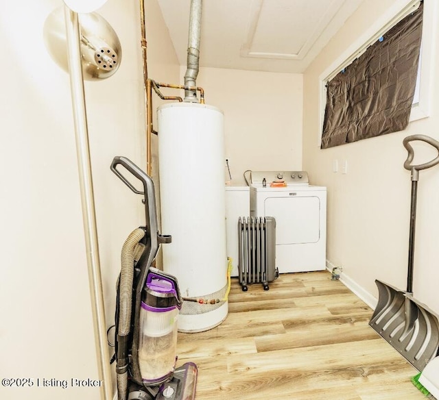 laundry room with laundry area, radiator heating unit, wood finished floors, washing machine and dryer, and gas water heater