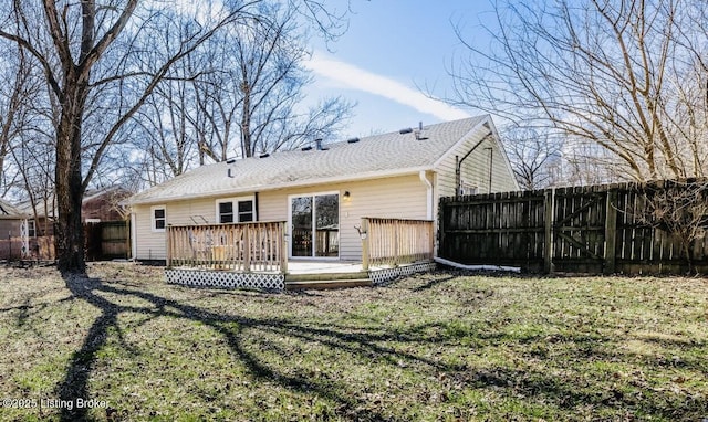 back of property featuring a lawn, fence, and a wooden deck