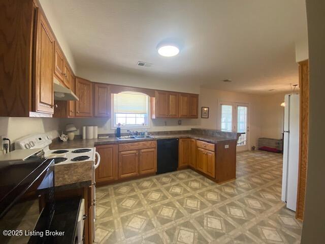 kitchen featuring a peninsula, black dishwasher, freestanding refrigerator, electric range oven, and light floors