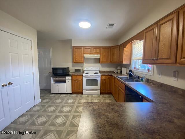 kitchen with light floors, under cabinet range hood, a sink, black appliances, and brown cabinetry