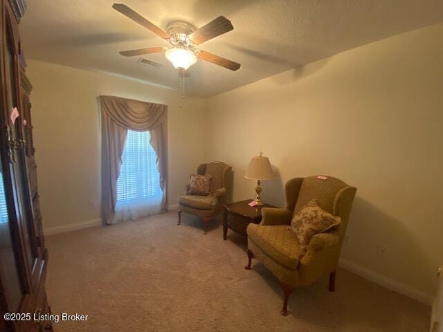 sitting room with a ceiling fan, carpet, visible vents, and baseboards