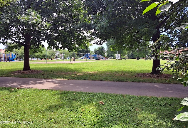 view of property's community featuring playground community and a yard