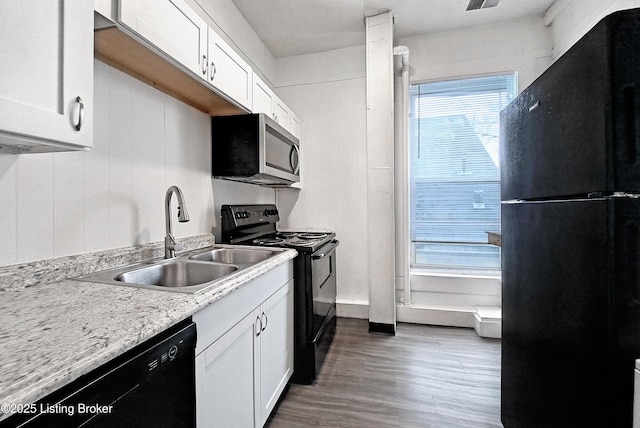 kitchen featuring black appliances, light countertops, a sink, and white cabinetry