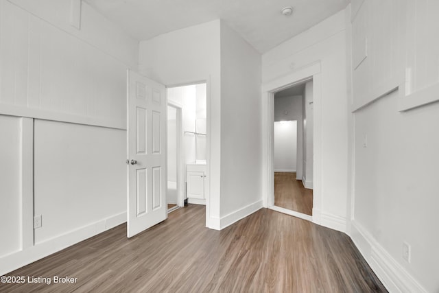 unfurnished bedroom featuring a closet, baseboards, and wood finished floors