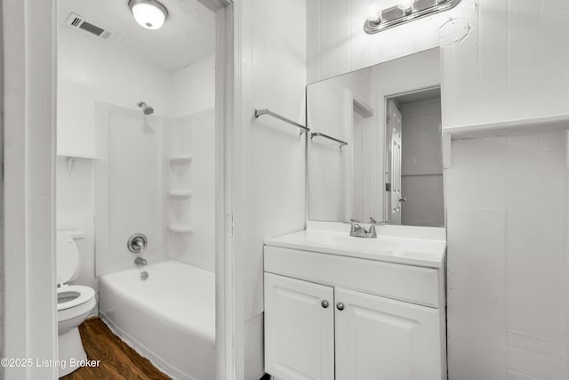 full bathroom with bathtub / shower combination, visible vents, toilet, vanity, and wood finished floors