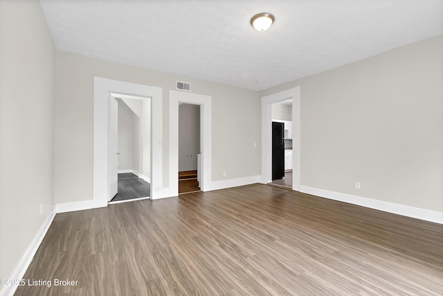 interior space with visible vents, baseboards, and wood finished floors