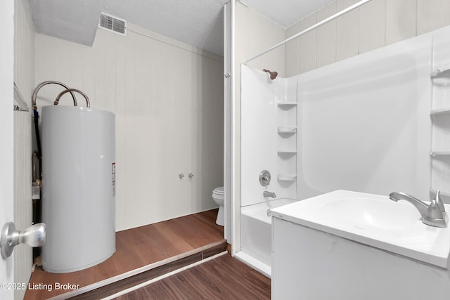 bathroom with gas water heater, shower / bath combination, visible vents, toilet, and wood finished floors