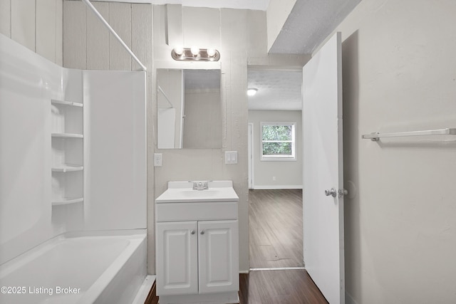 bathroom featuring  shower combination, wood finished floors, and vanity